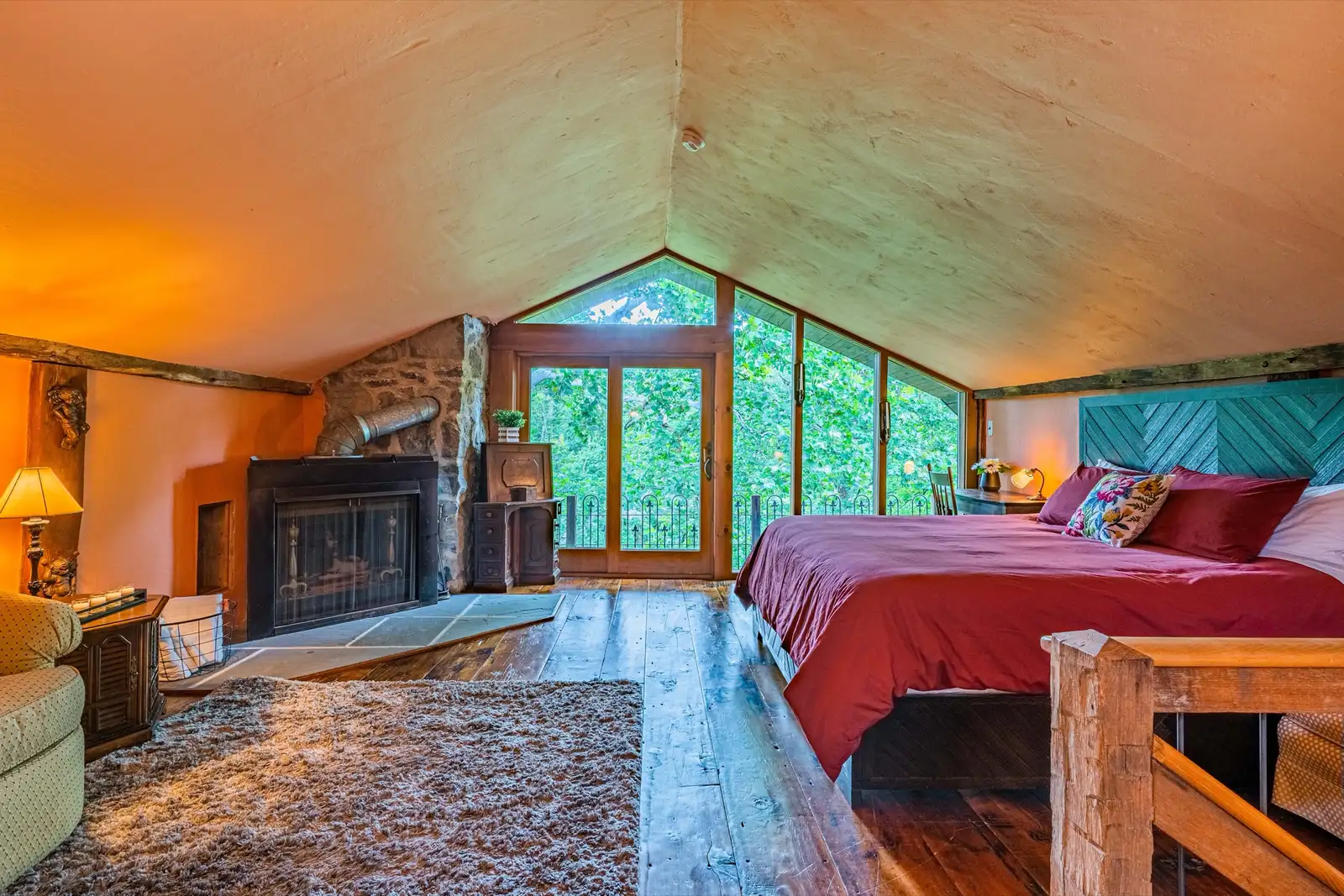 Bedroom with exposed stone wall, wooden beams, and warm lighting