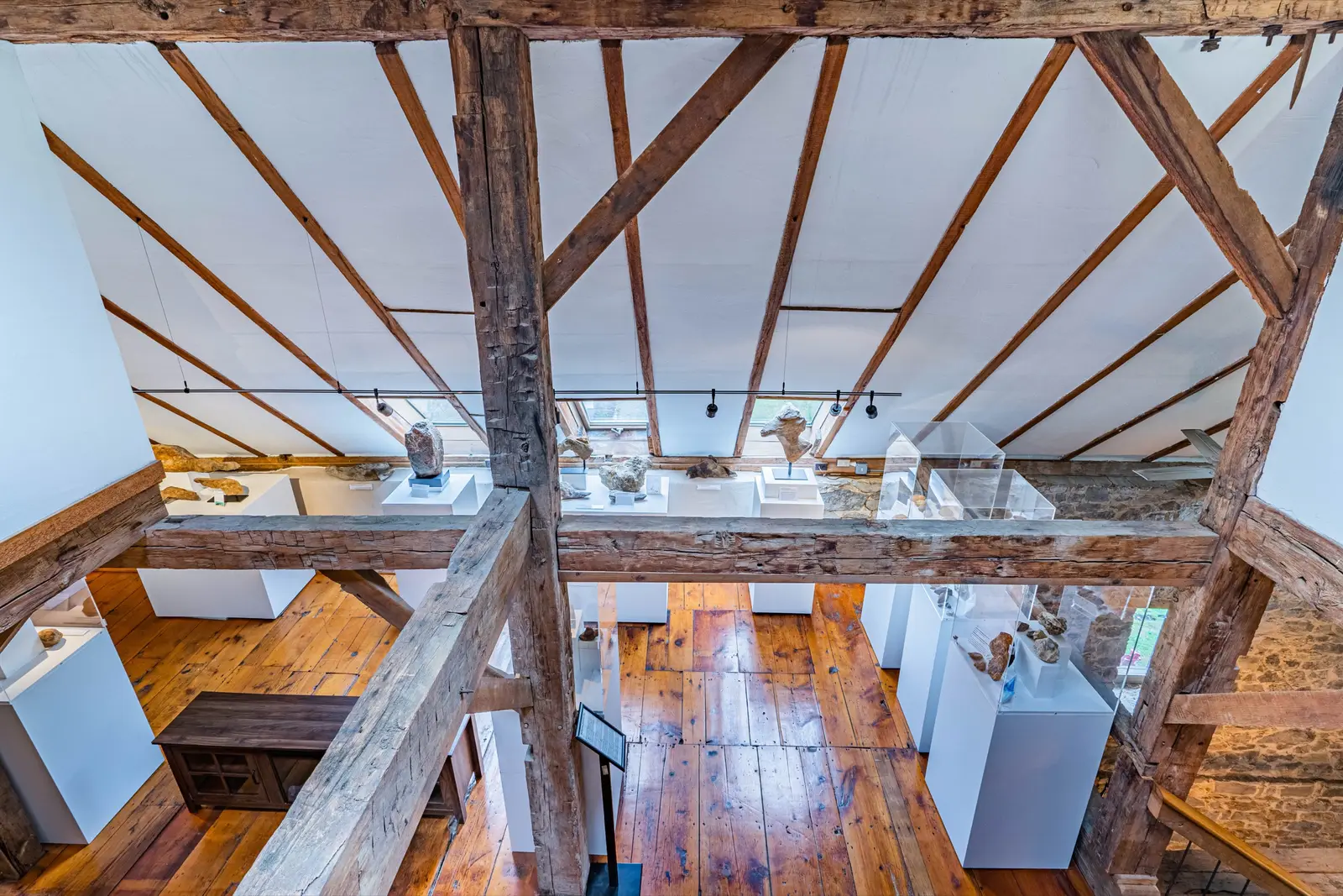 Open living area with hand-hewn beams and view through to stone staircase
