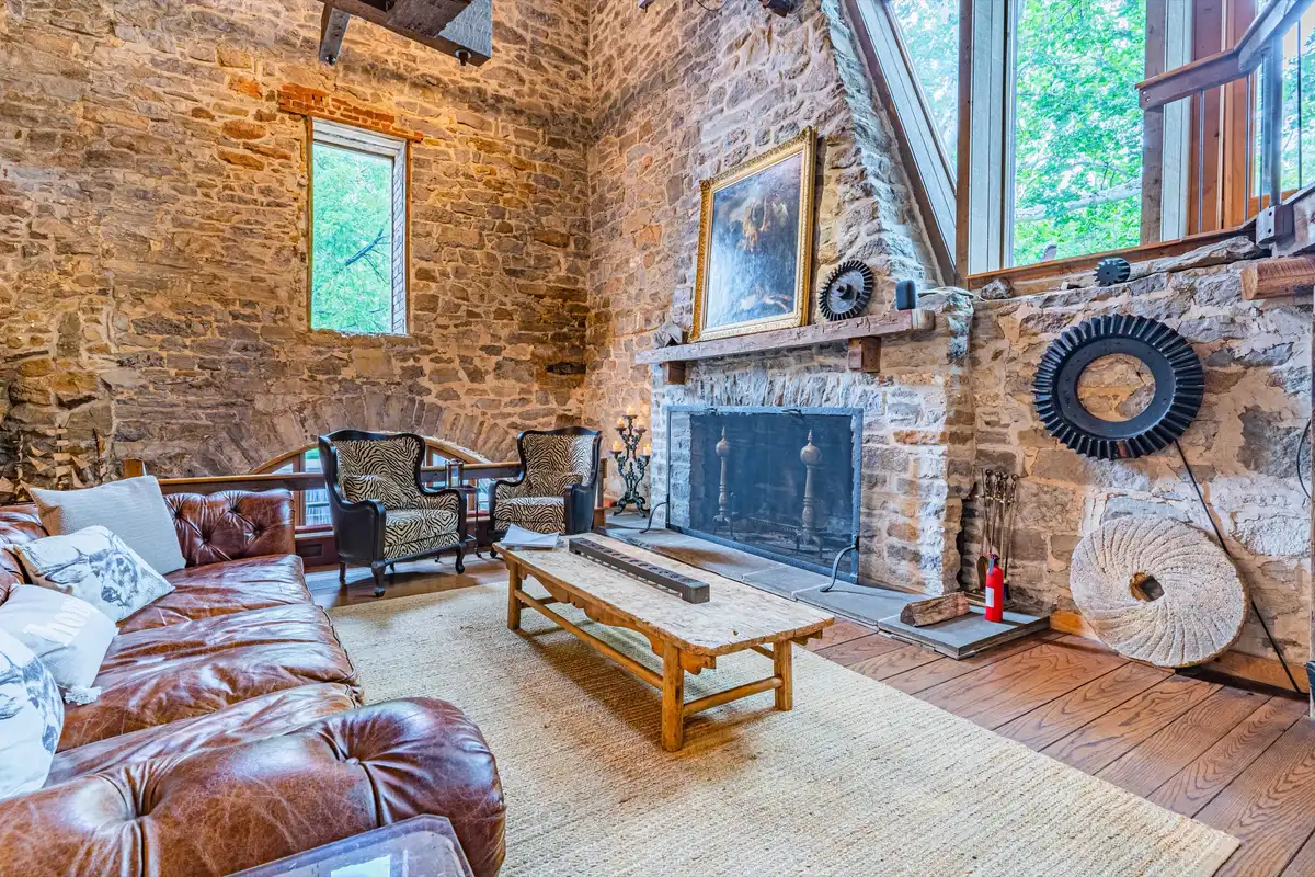 Fireplace detail with oil painting, original millstone gear, and artwork