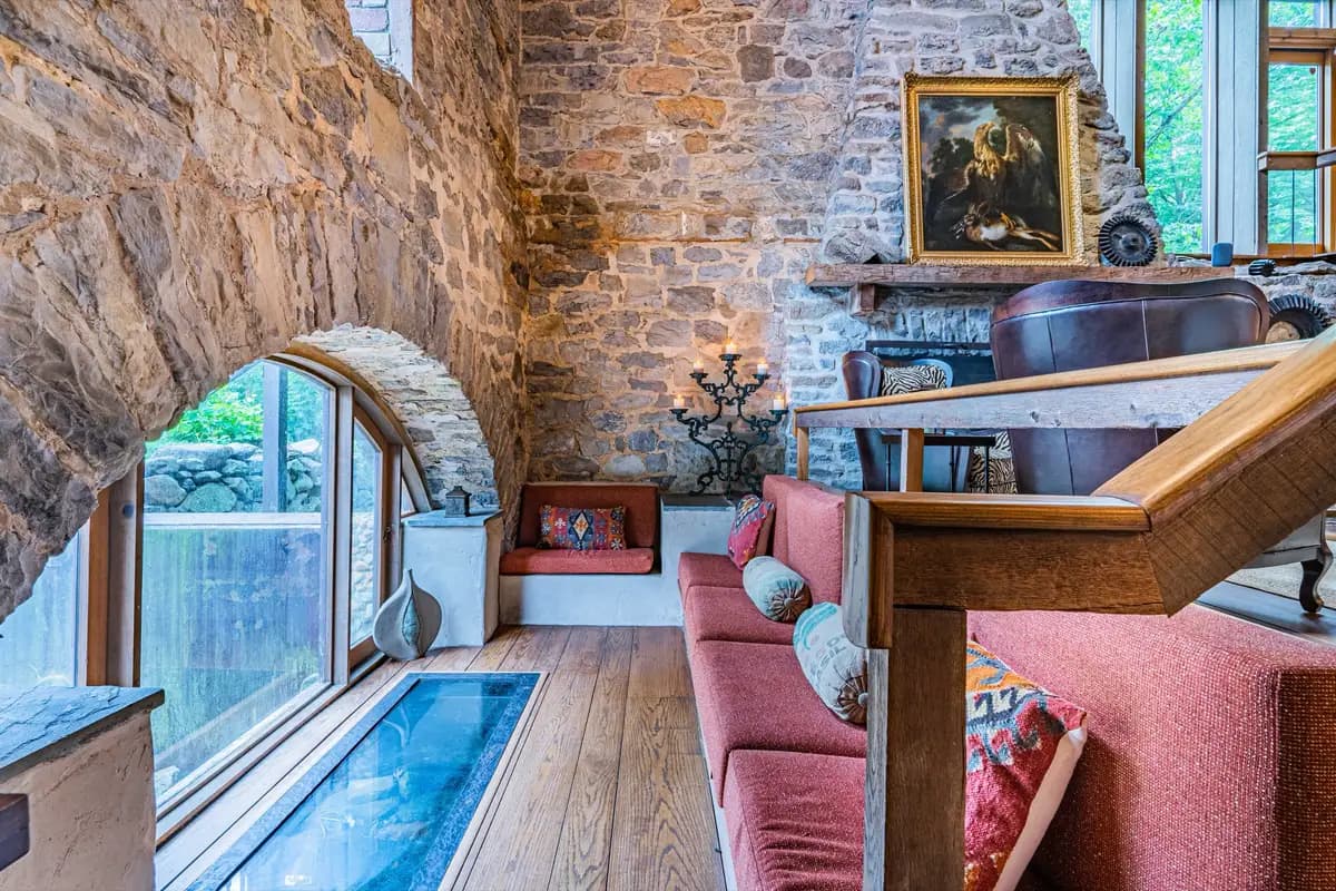 Stone-walled sitting nook with arched window overlooking the millrace below