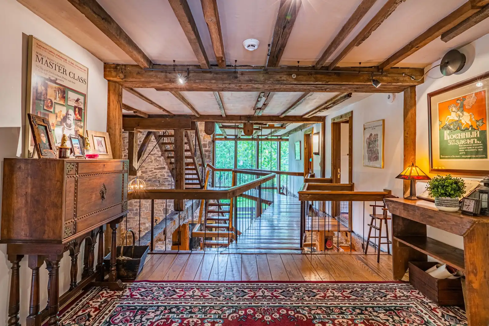 Upper landing with antique piano, Persian rug, and view down to staircase