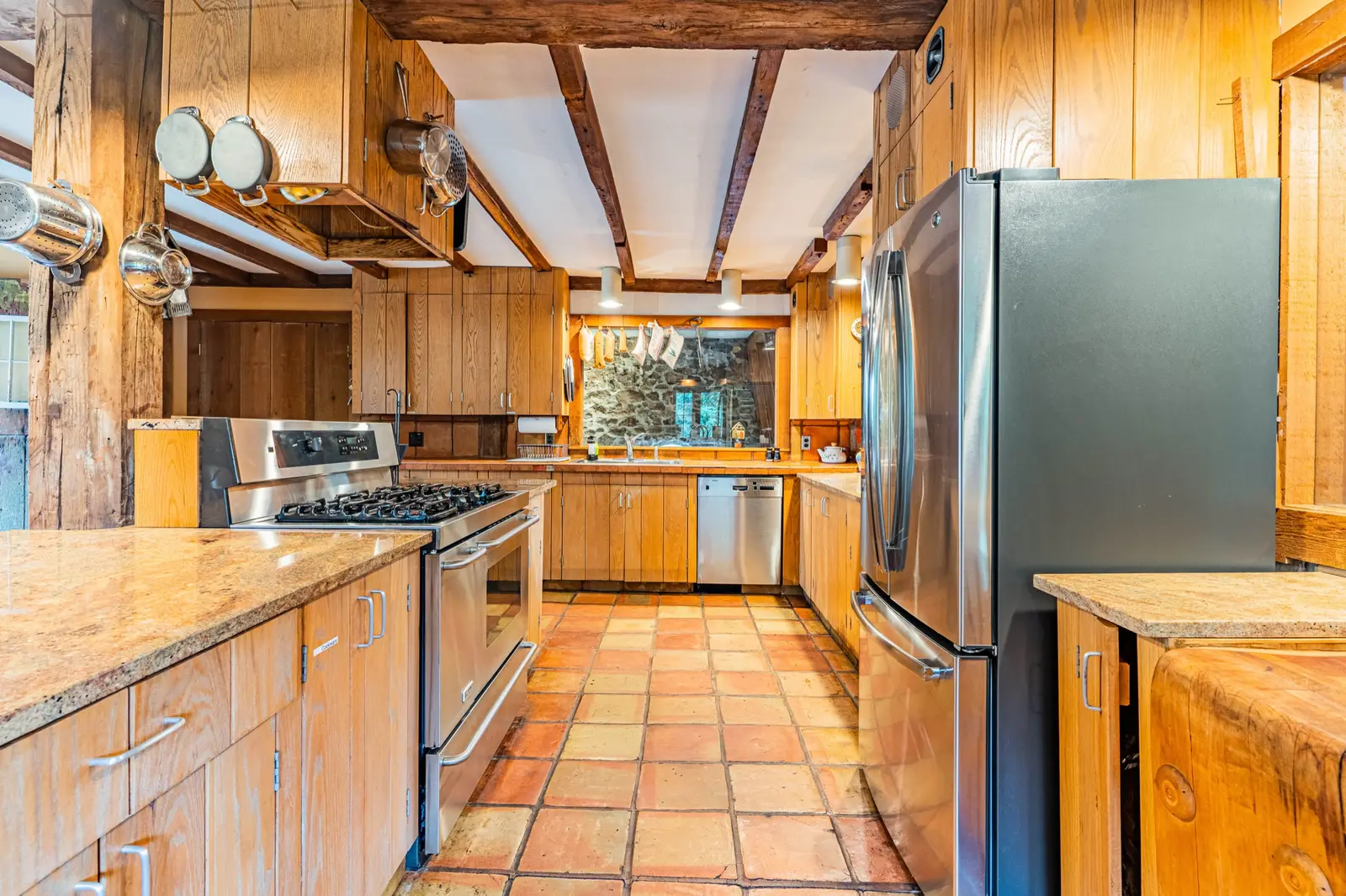 Galley kitchen with wood cabinets and stainless steel appliances