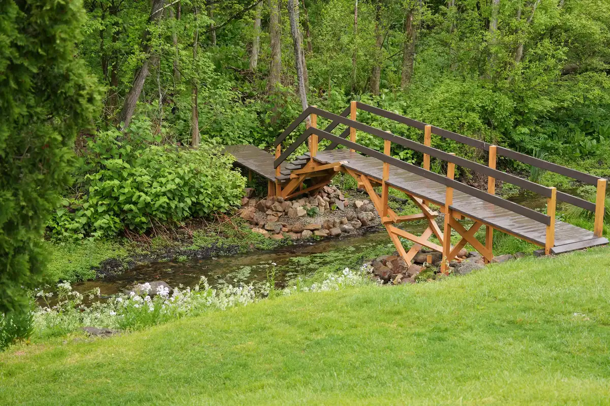 Wooden footbridge crossing the millstream at the edge of the lawn