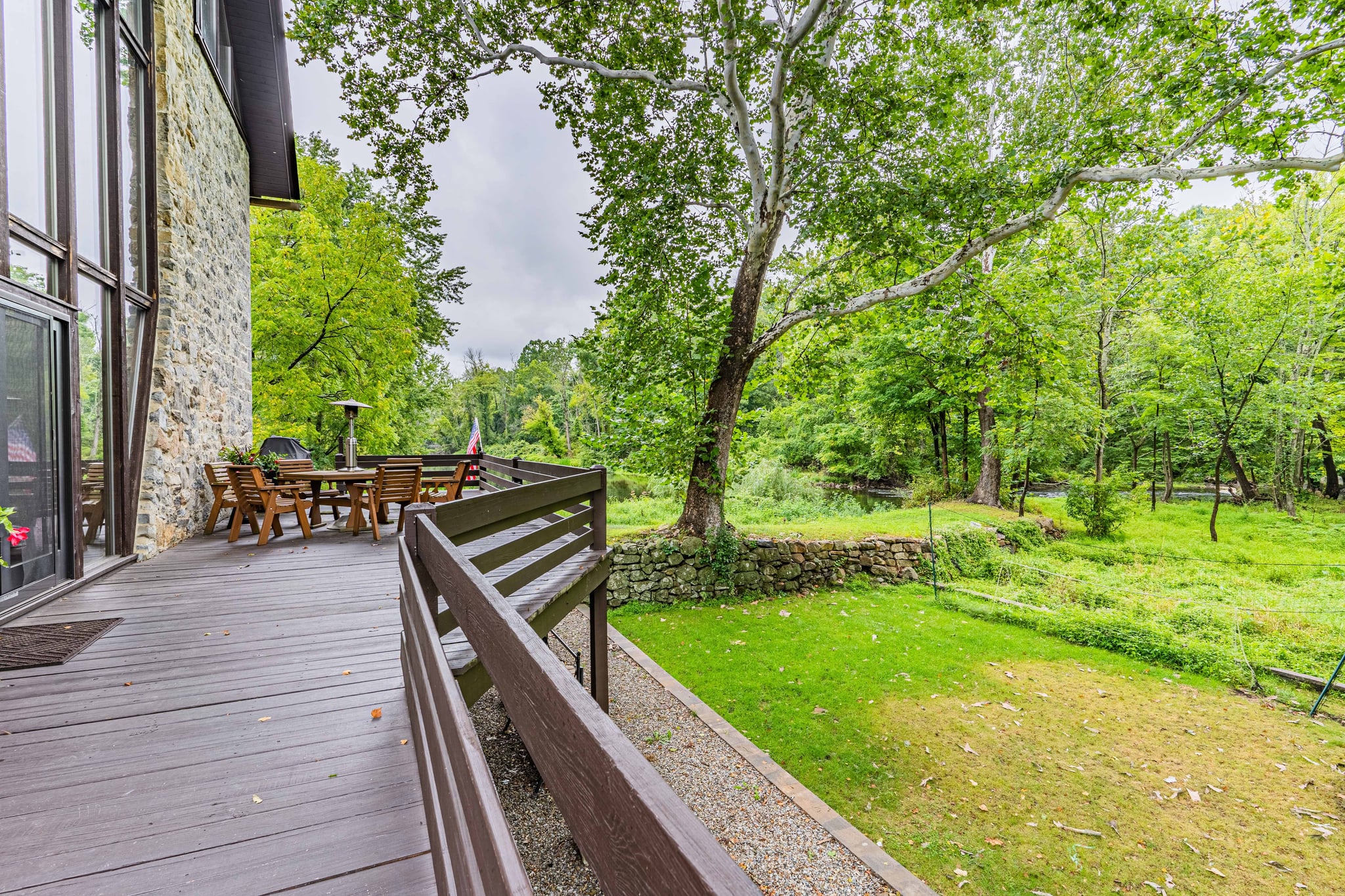 Wooden deck with outdoor dining table overlooking the green grounds