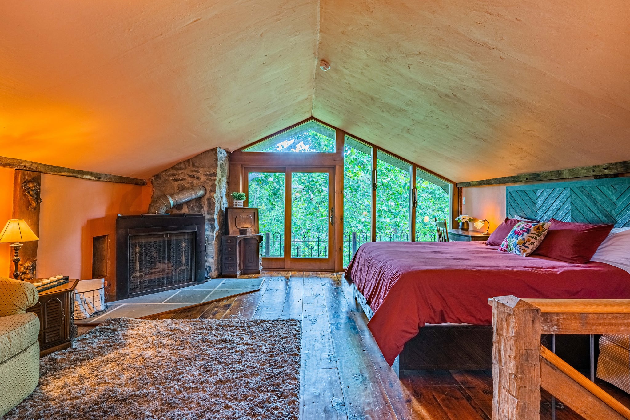 Bedroom with exposed stone wall, wooden beams, and warm lighting