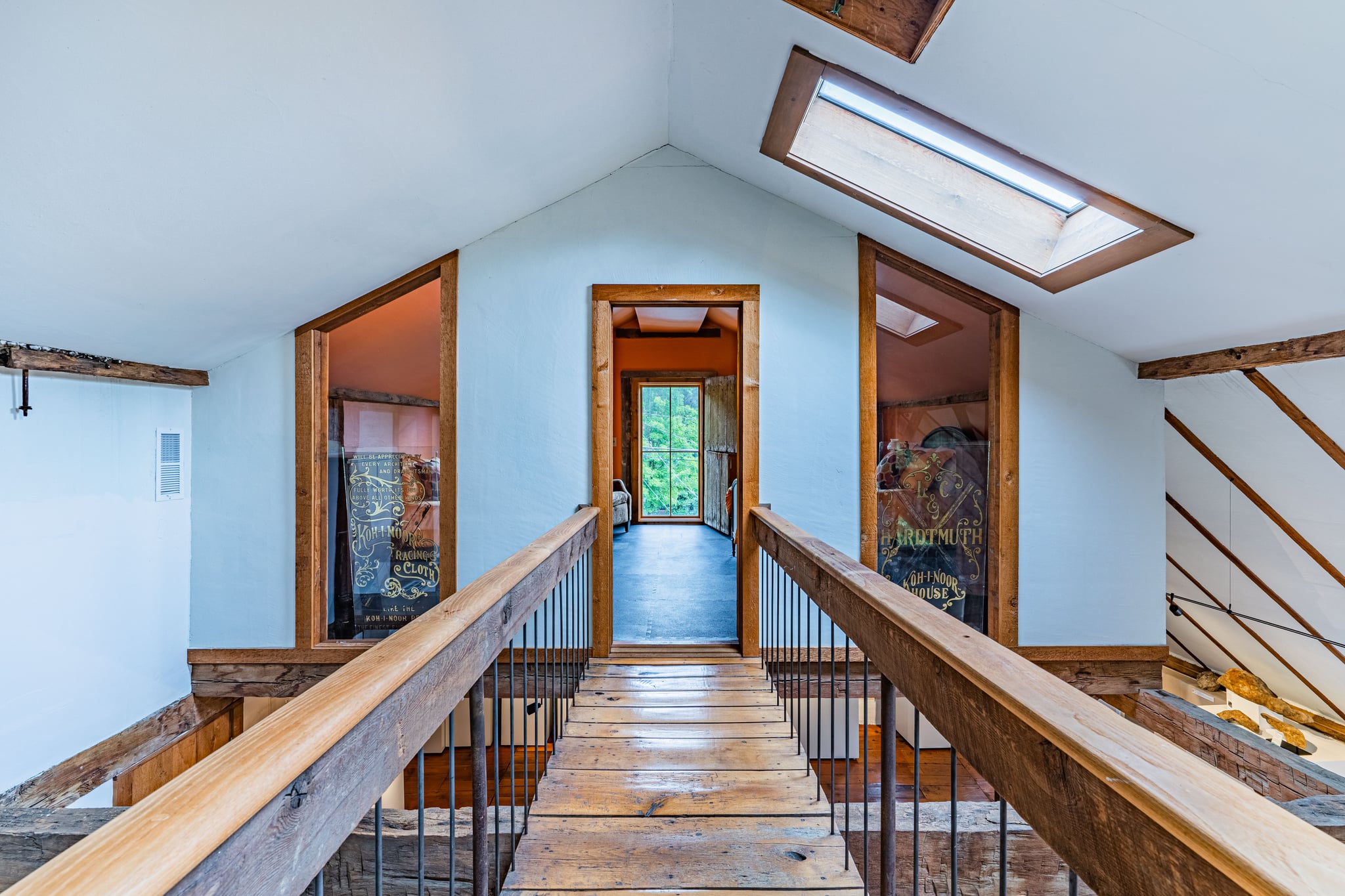 Upper hallway with skylights, hand-hewn timber framing, and original wood floors
