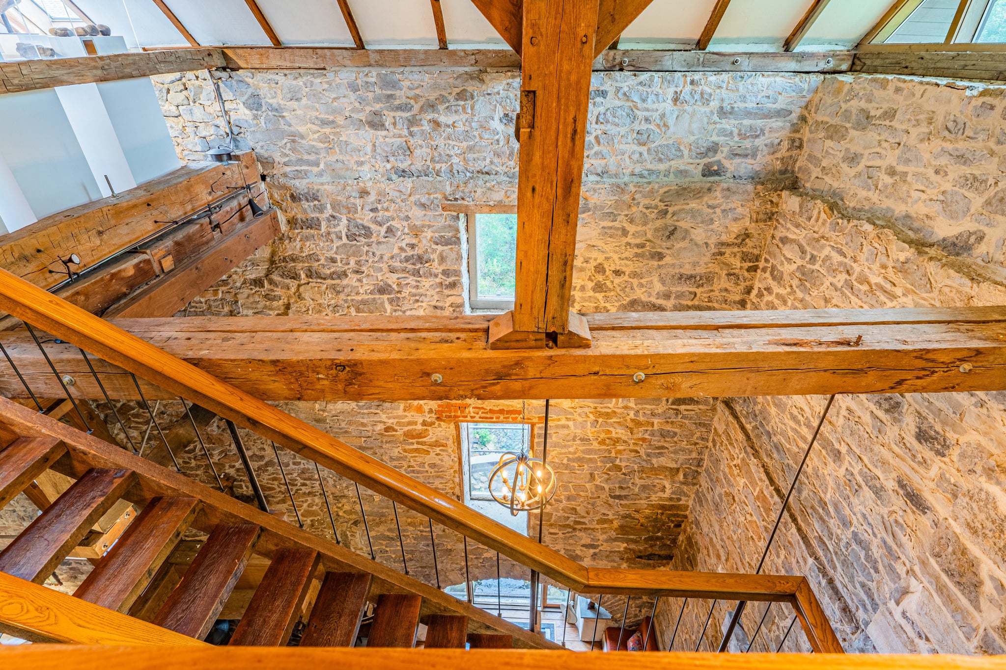 Multi-story view looking up through wooden staircases and stone walls
