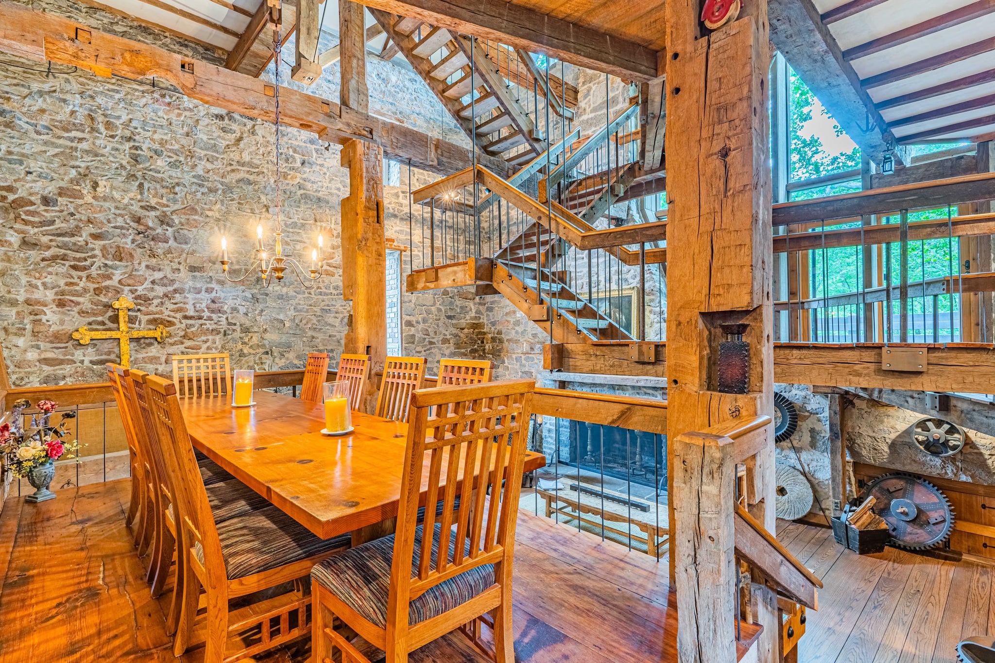 Dining area with antique wooden table, chandelier, and stone walls