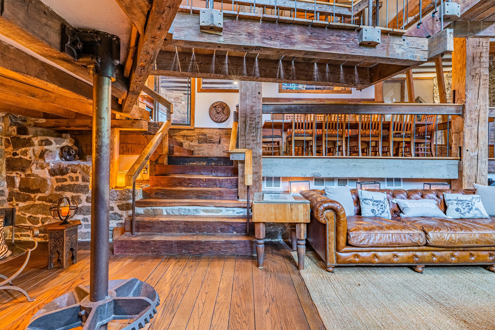 Staircase landing with leather seating and hanging wine glasses above