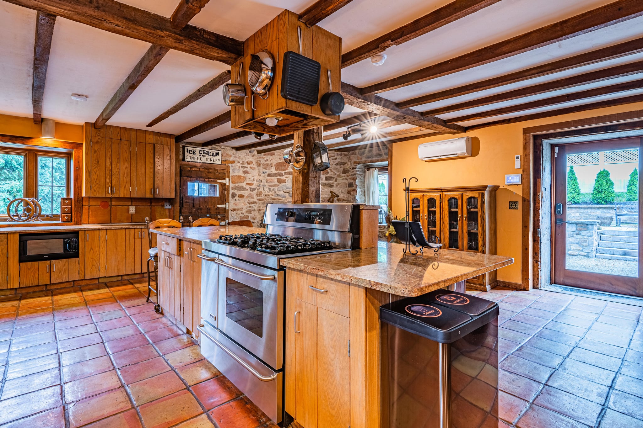 Stone fireplace close-up with oil painting, antique chair, and millstone gear