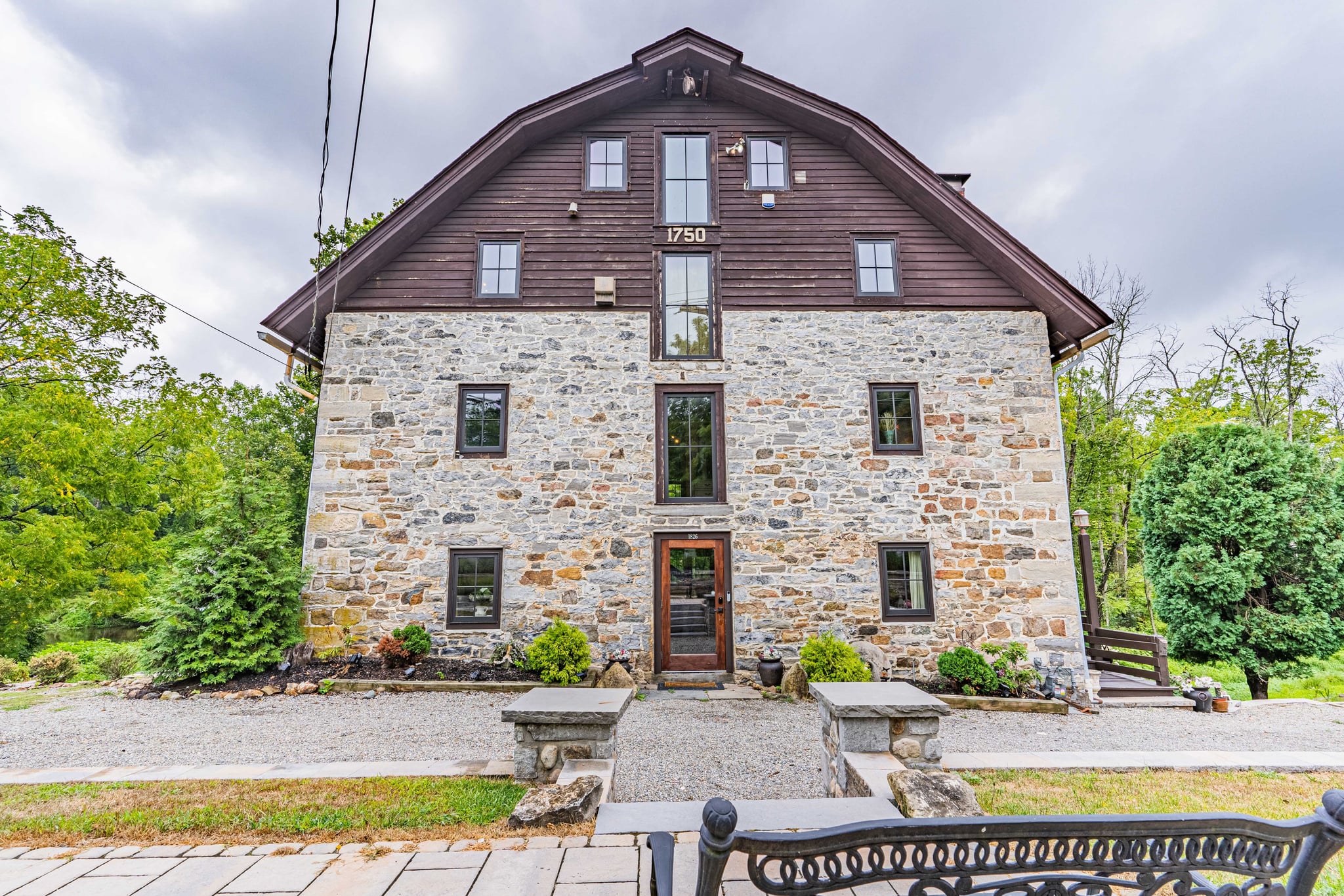 Front facade of the 1762 stone mill showing original stonework and gambrel roof
