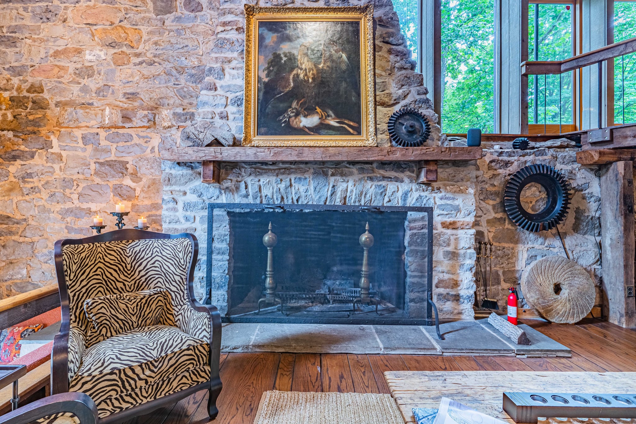 Grand living room with stone fireplace, leather sofa, and original millstone decor